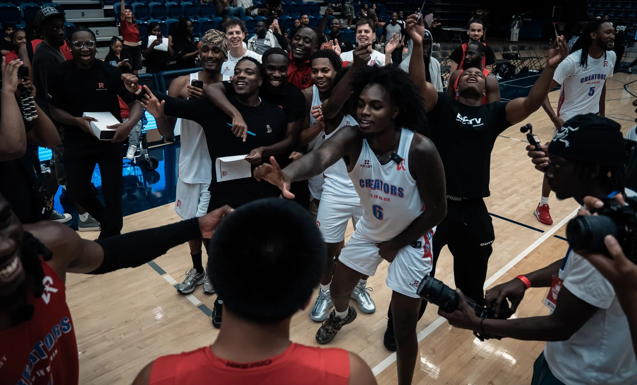Players and community members celebrate together on the basketball court at Mania Weekend 2026.