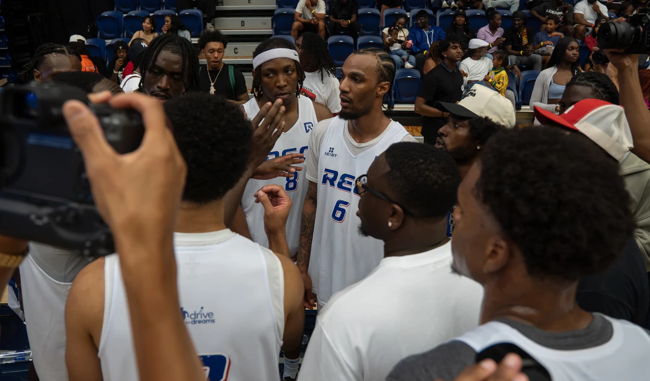 Attendees gather around a player for a photograph after a Mania Weekend game.